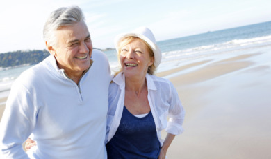 Happy senior couple walking on beach