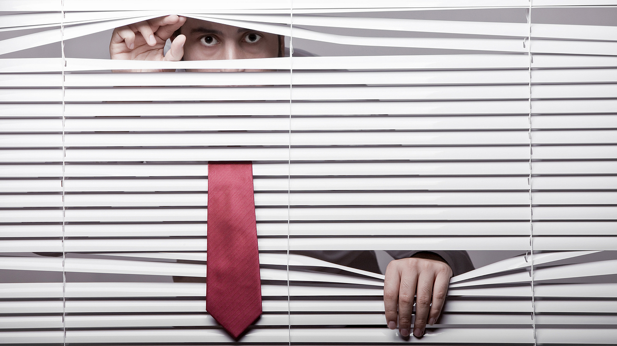 Man Watching through window blinds