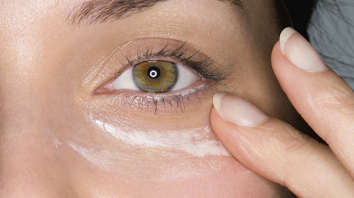 Woman applying moisturiser