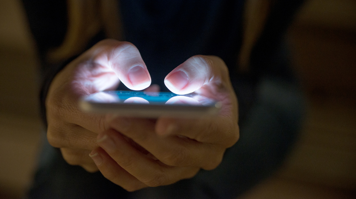 Female using her mobile phone outside at night