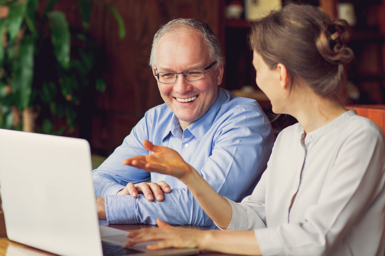 Two Smiling People Discussing Issues in Cafe