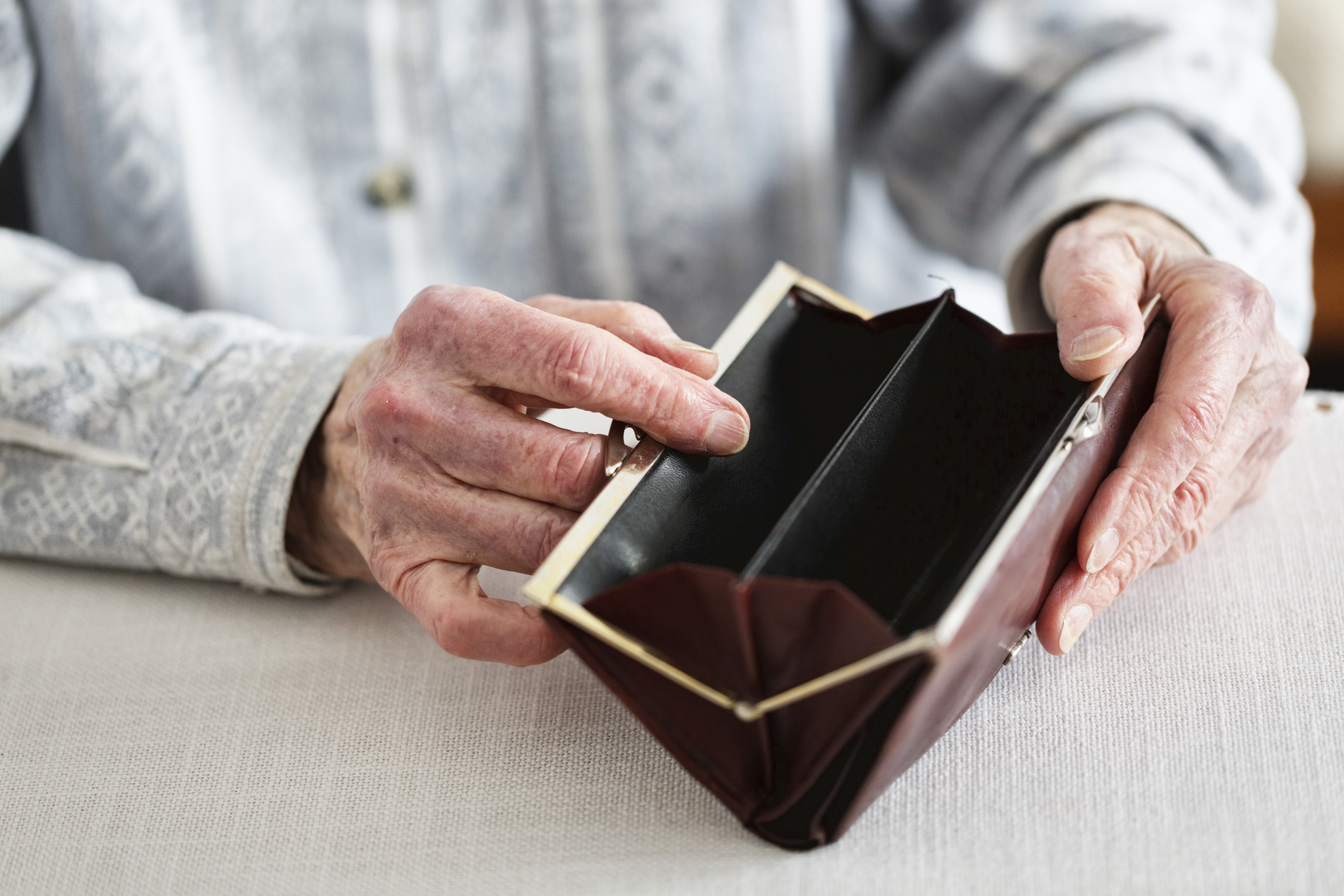 hands of senior adult holding empty purse