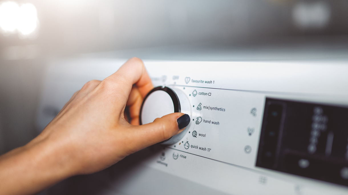 Woman choosing program on washing machine
