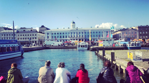 People enjoying beautiful view on Market Square and marina in old Helsinki , Finland
