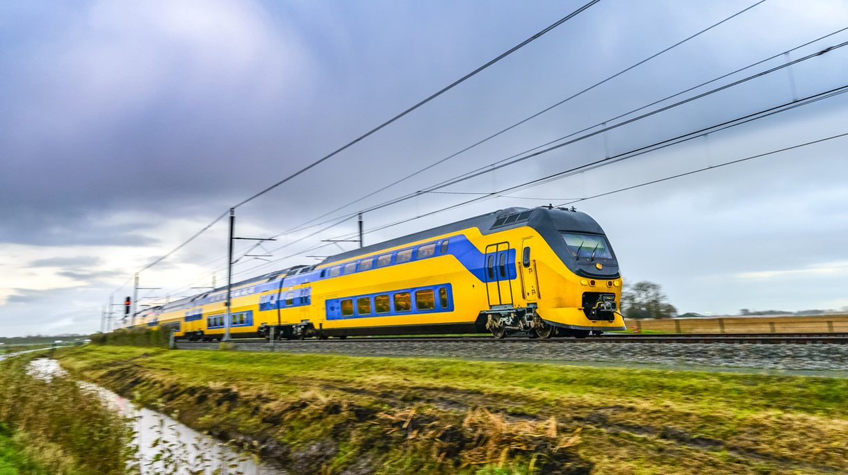 Train driving in a rural landscape during a dark day