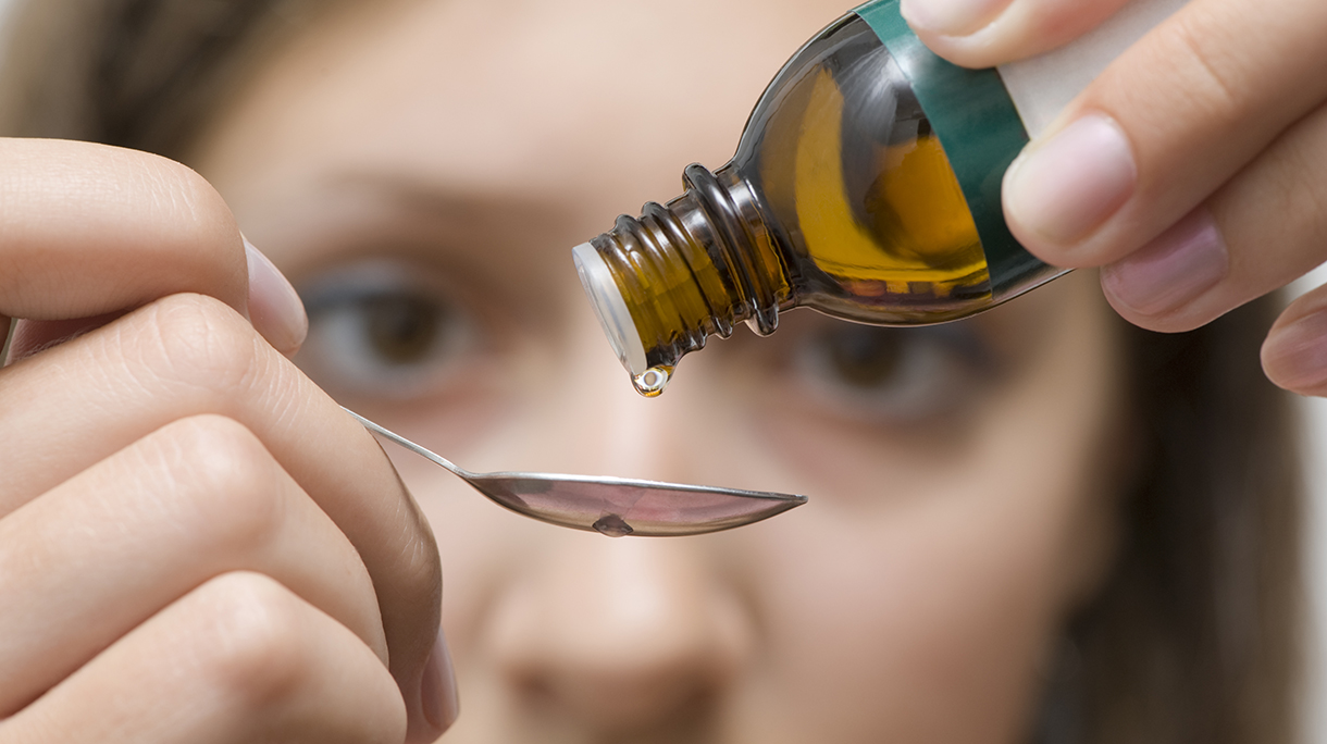 Brown eyed woman trying to correctly dose an herbal medicine