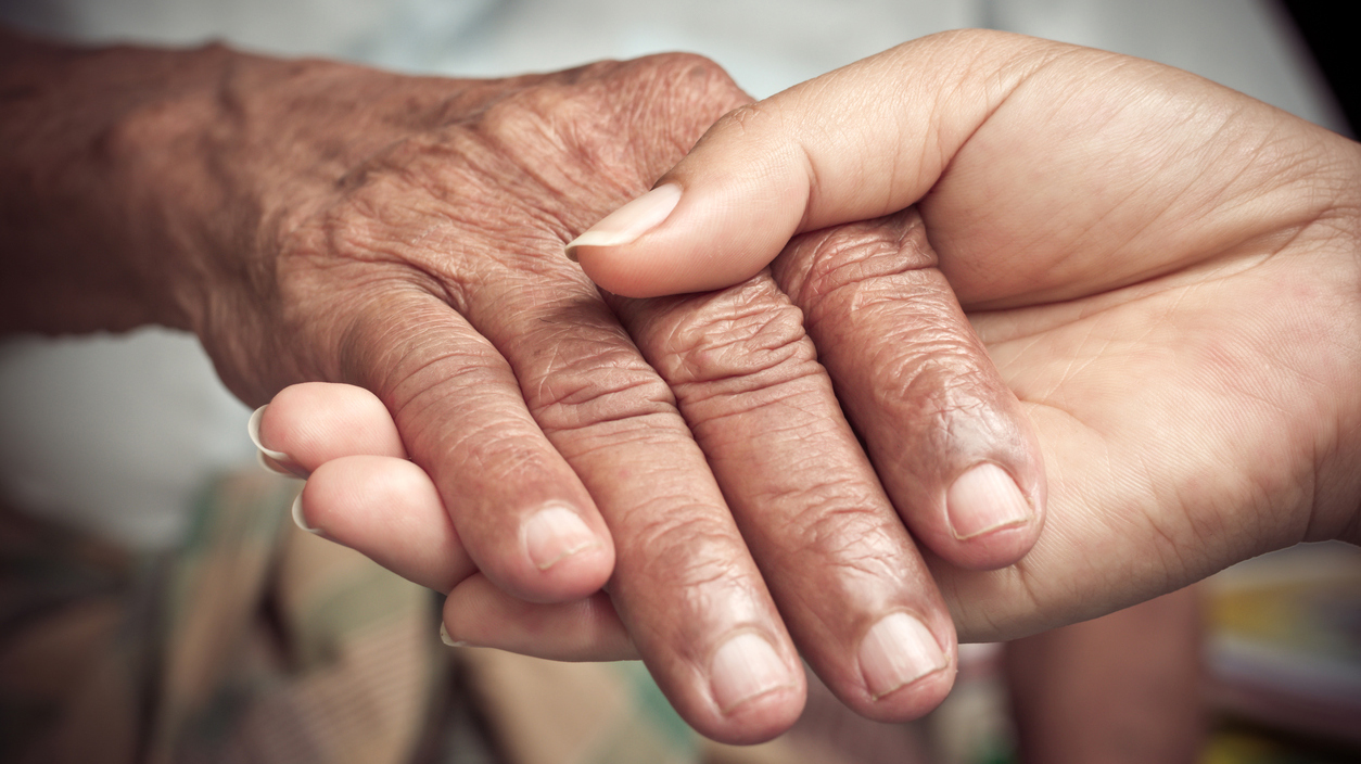 Senior and young holding hands