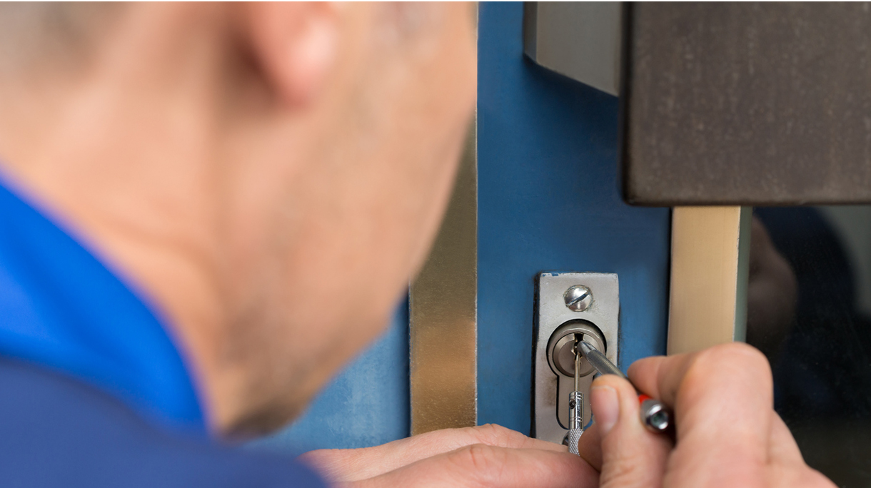 Close-up Of Male Lockpicker Fixing Door Handle At Home