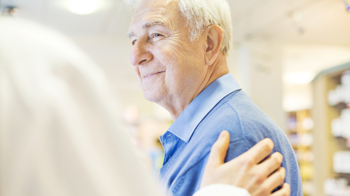 Smiling senior man looking at pharmacist