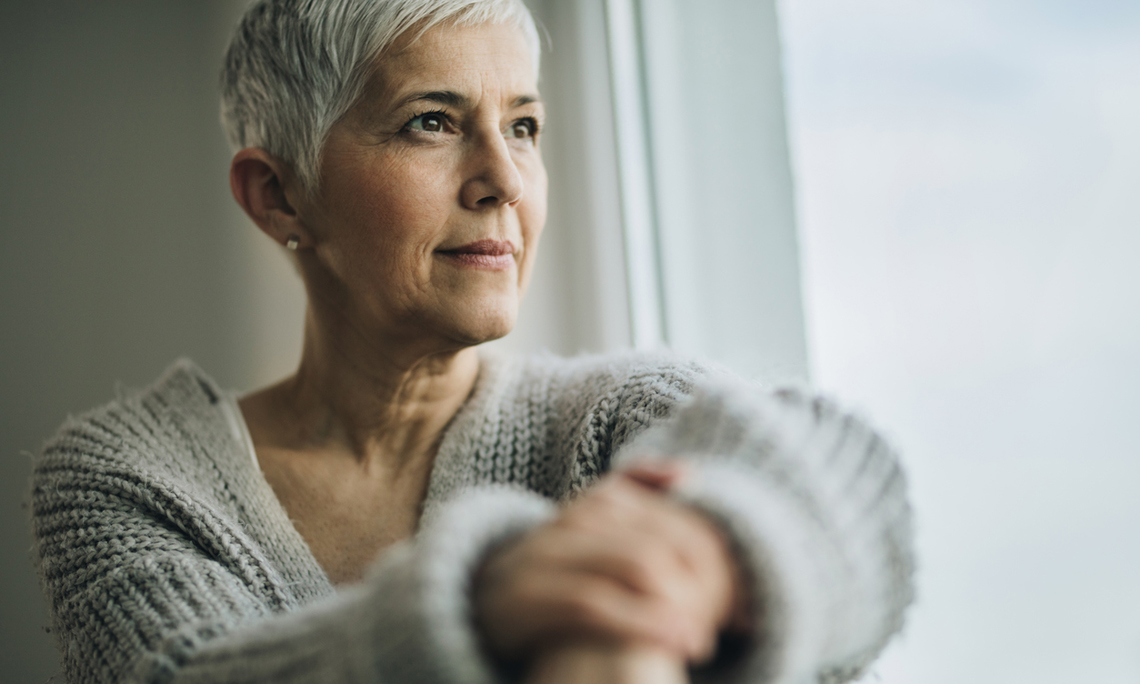 Portrait of beautiful mature woman relaxing by the window.