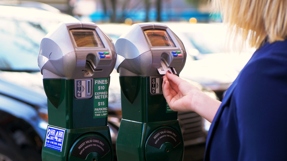 women-putting-coins-into-parking-meter-picture-id887711382