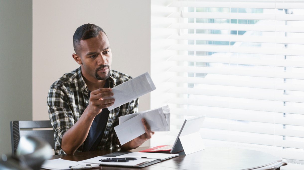 young-black-man-paying-bills-at-home-picture-id647093800