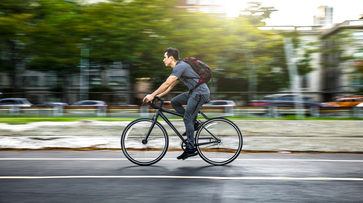 Young man cycling in the city, commuting to work