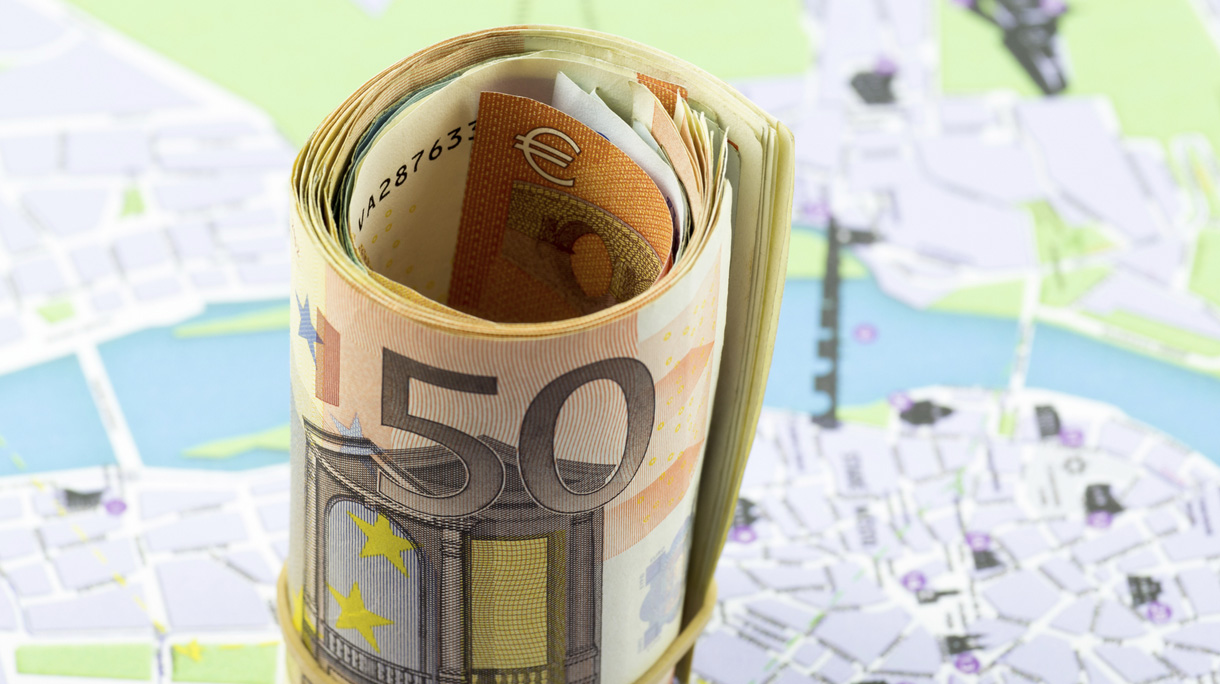 Fifty Euro rolled up on a map as a background