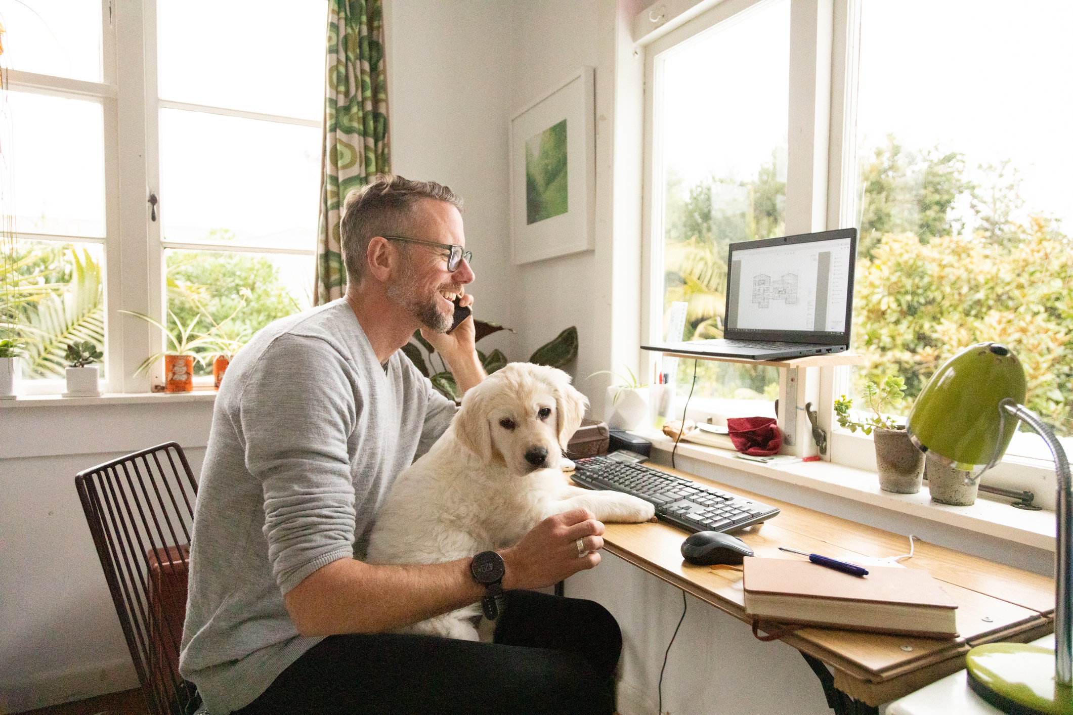 Man working from home with cute puppy on his knee