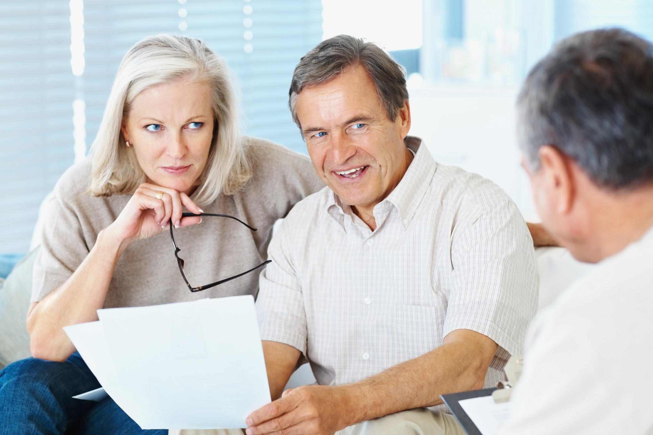 Couple in discussion with a financial advisor at home