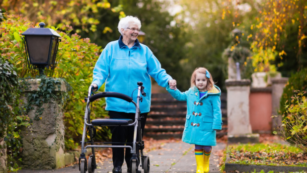 Senior lady with walker enjoying family visit in the park