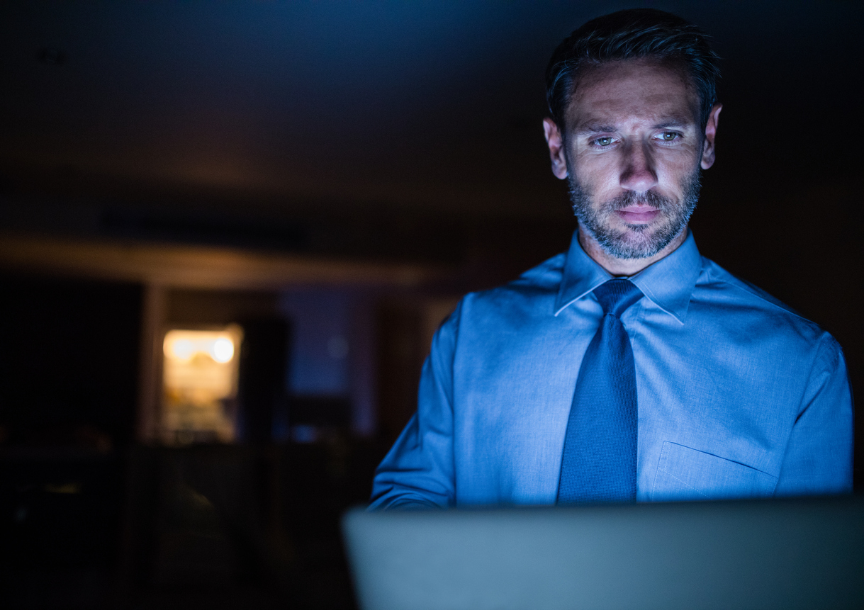 Late night working man using laptop in the dark