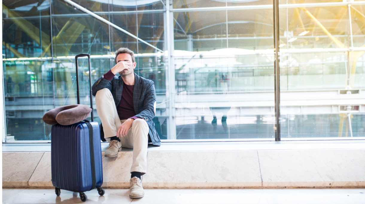 man-upset-sad-and-angry-at-the-airport-his-flight-is-delayed-picture-id821828894