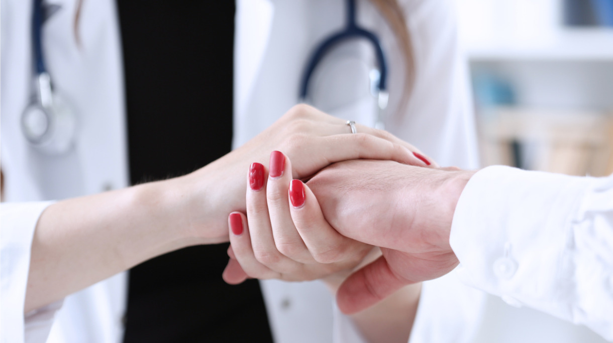 friendly-female-doctor-hold-male-patient-hand-in-office-picture-id8138649141_0