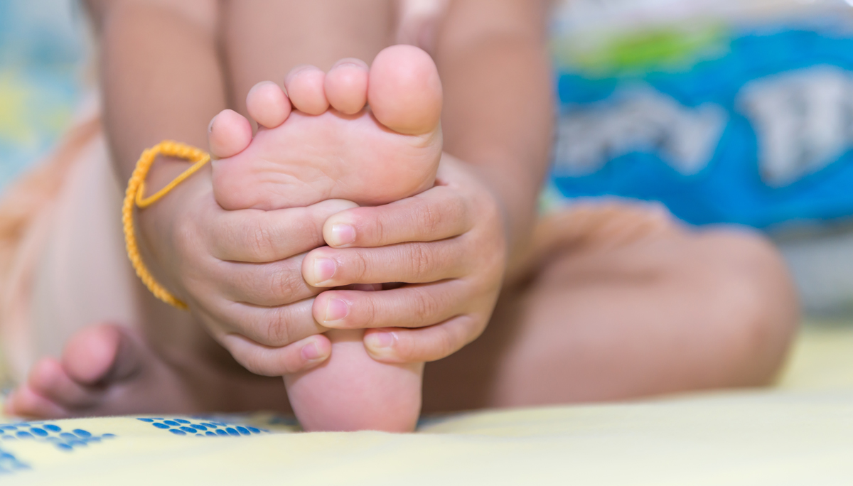 little girl massaging his aching feet