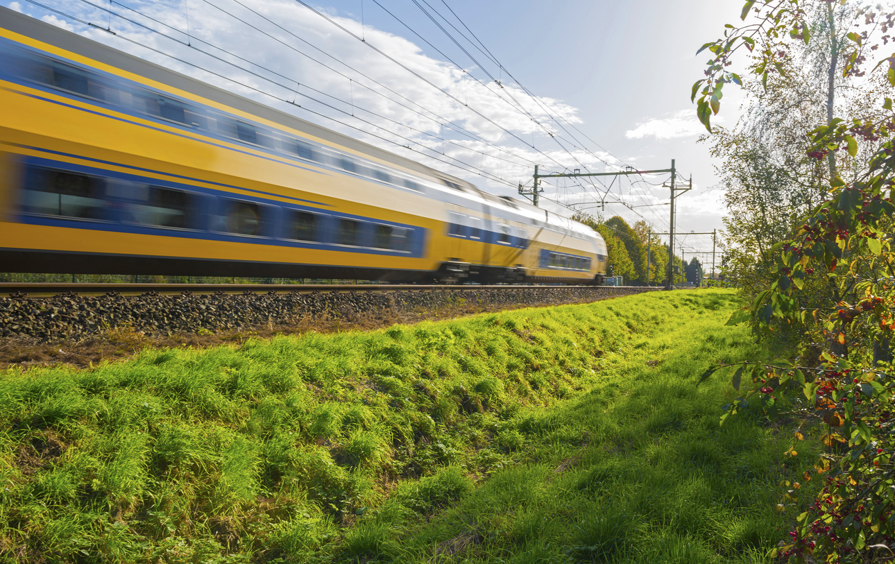 Passenger train moving at high speed in sunlight