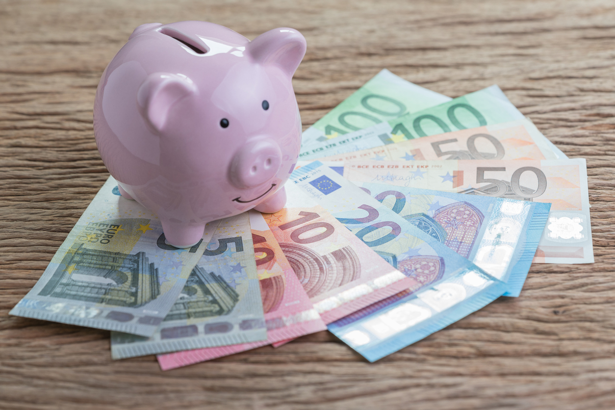 Pink piggy bank on pile of Euro banknotes on wooden table, financial savings money account or Europe economics concept, future growth of interest compound in saving or investing idea