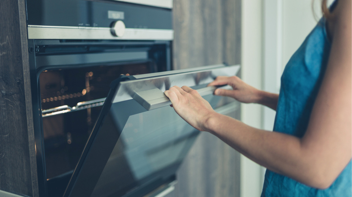young-woman-opening-the-oven-picture-id869762932