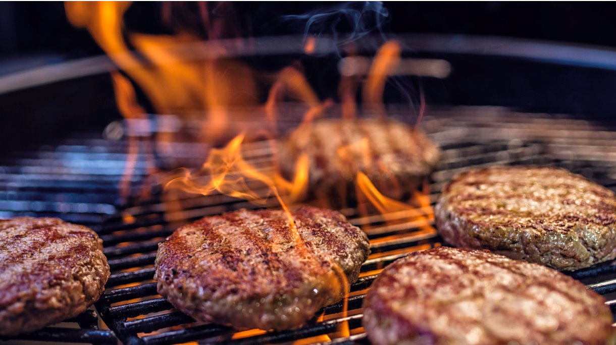 closeup-of-meat-patties-on-a-barbecue-picture-id543441106