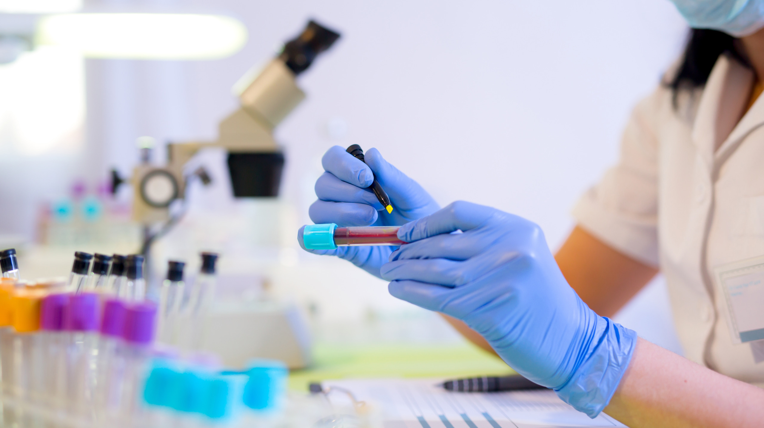 Woman working in a laboratory, writing with a felt pen.