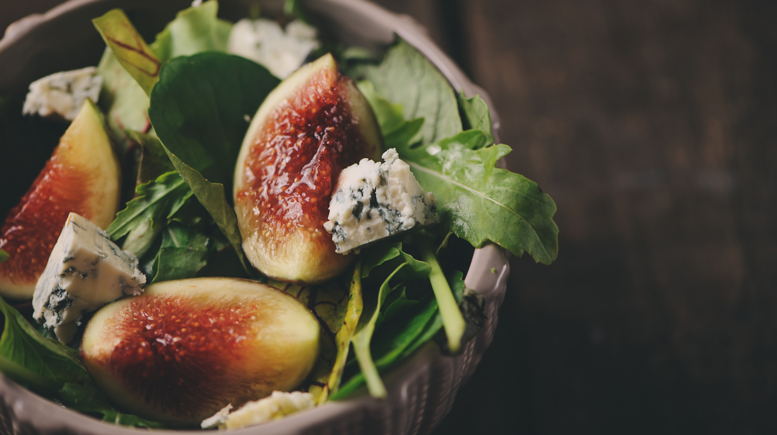 figs salad with blue cheese and ruccola on wooden background