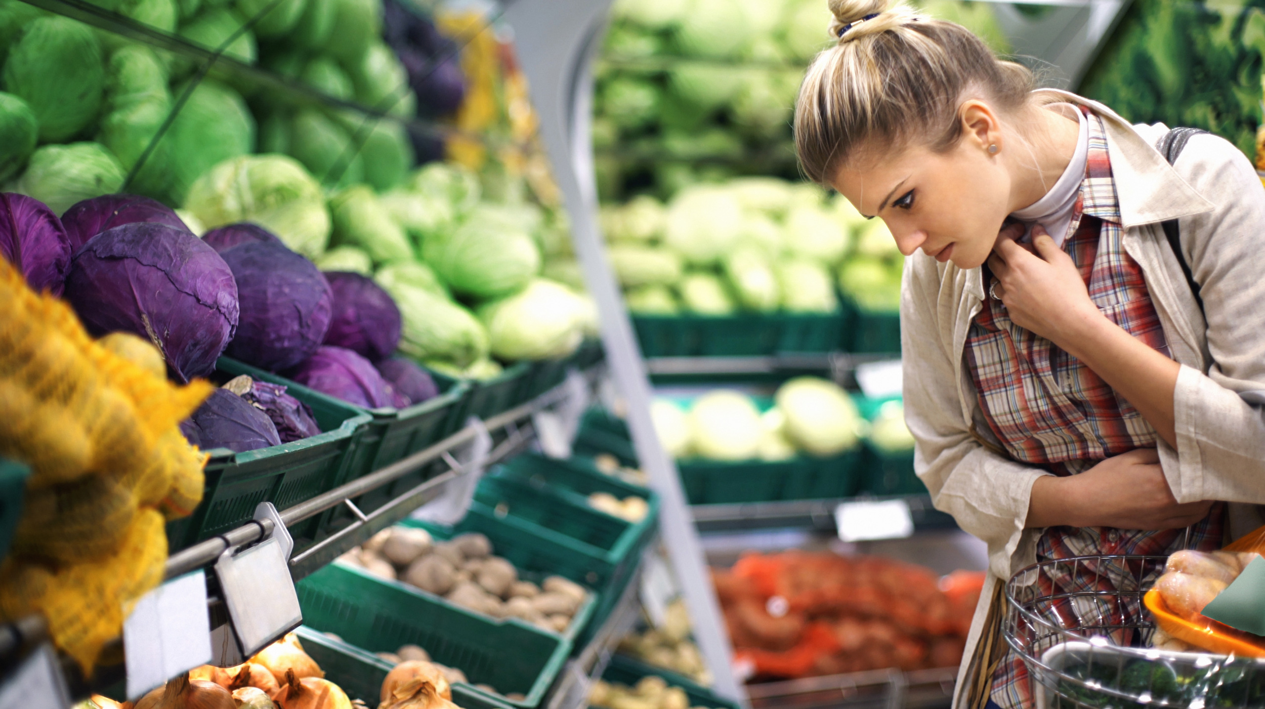 Woman buying vegetables at a supermarket.