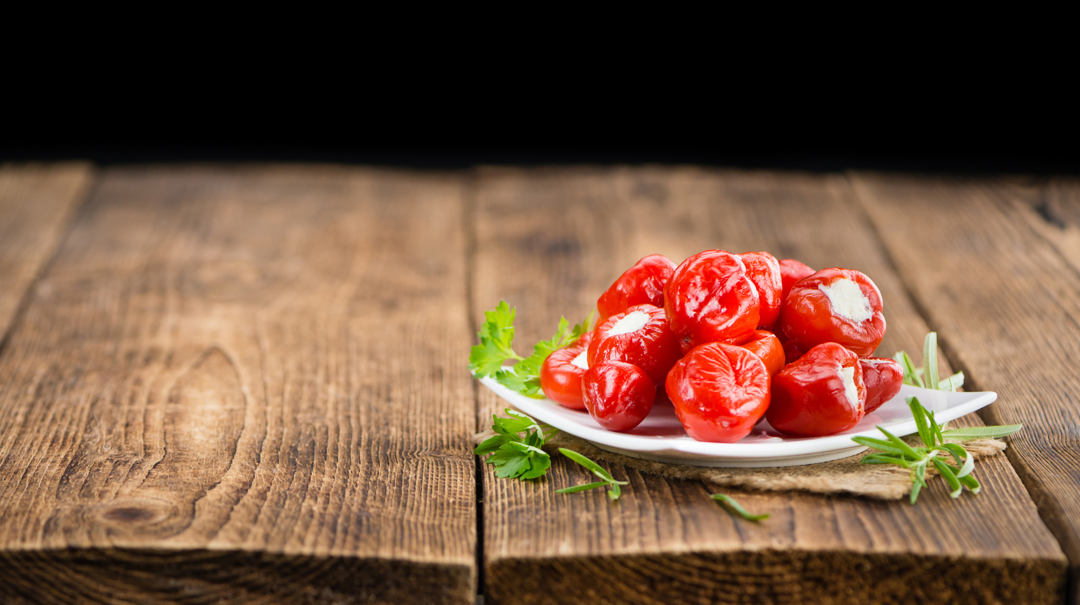 Portion of Red Pepper (stuffed with cheese) on wooden background (selective focus)