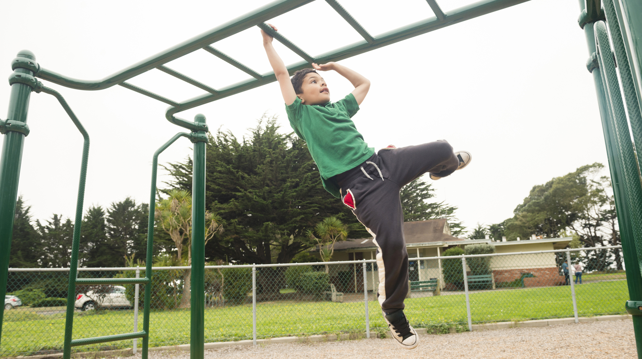 Young California Boy Swinging on Monkey Bars