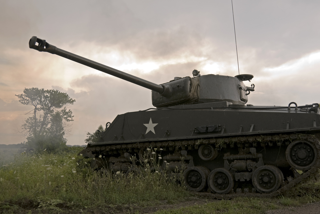 Mark IV Sherman tank driving through field on cloudy day