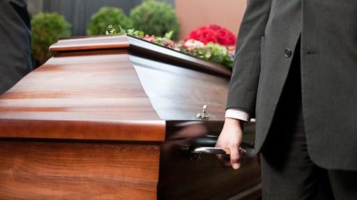 Funeral with casket carried by coffin bearer