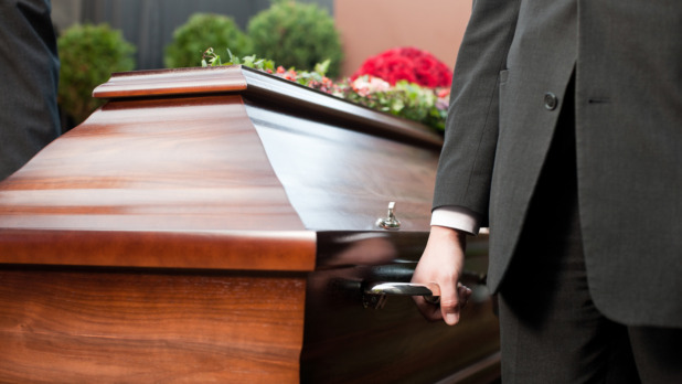 Funeral with casket carried by coffin bearer