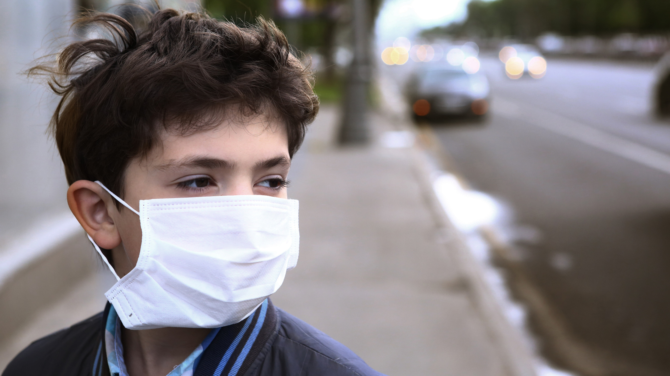 teenager boy in protection mask on the highway city