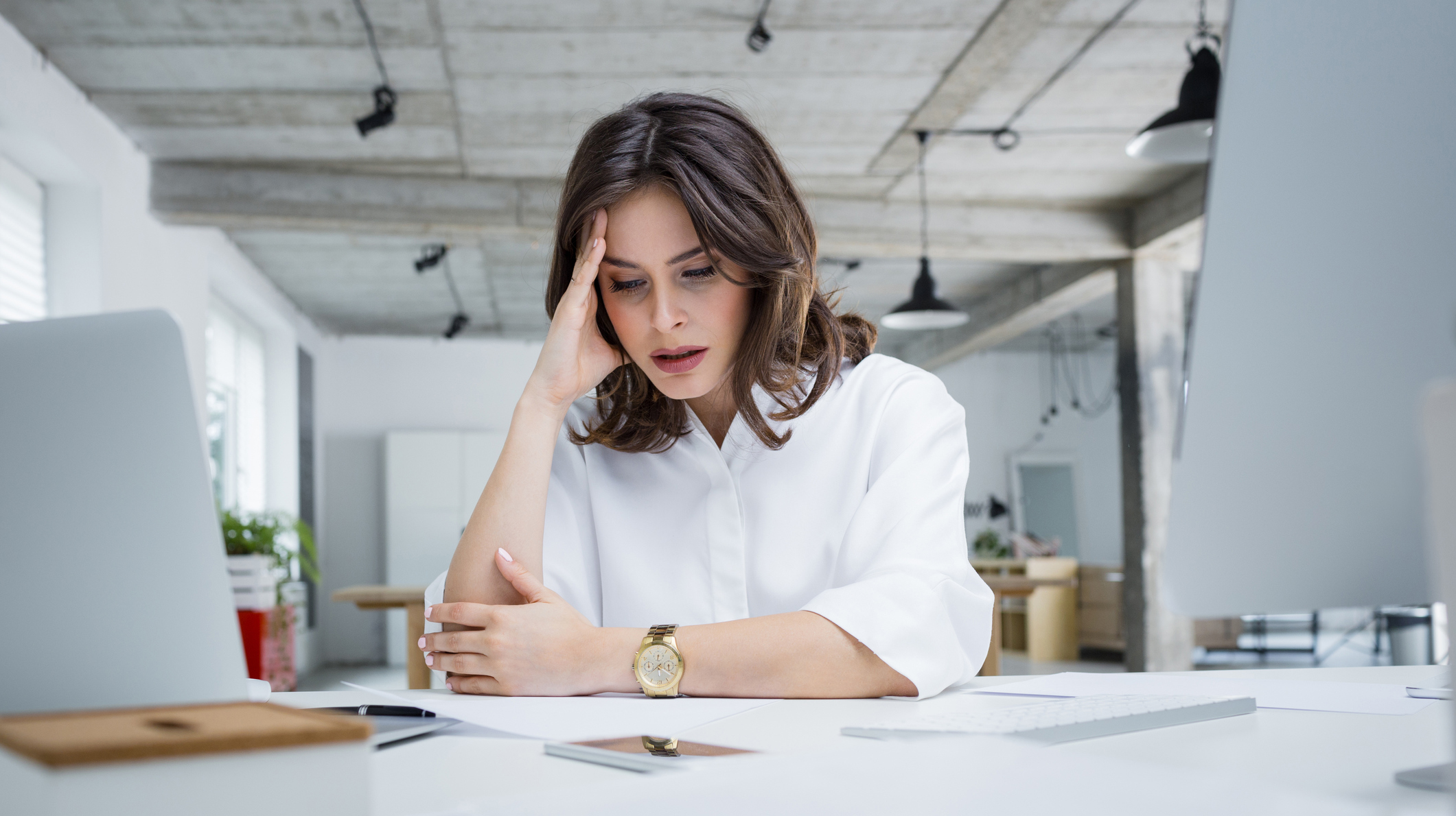 Female entrepreneur with headache sitting at desk