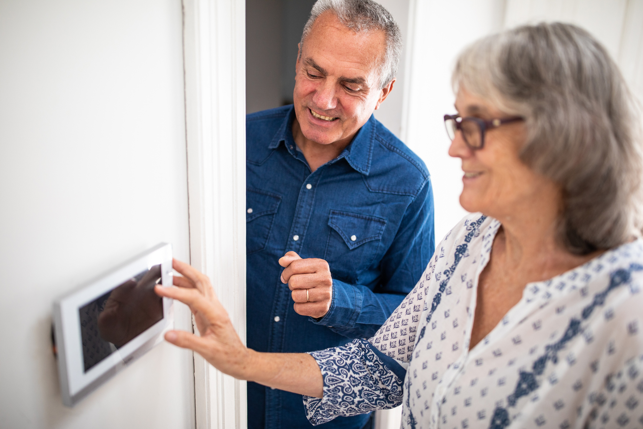Senior man explaining to his wife how to set burglar alarm