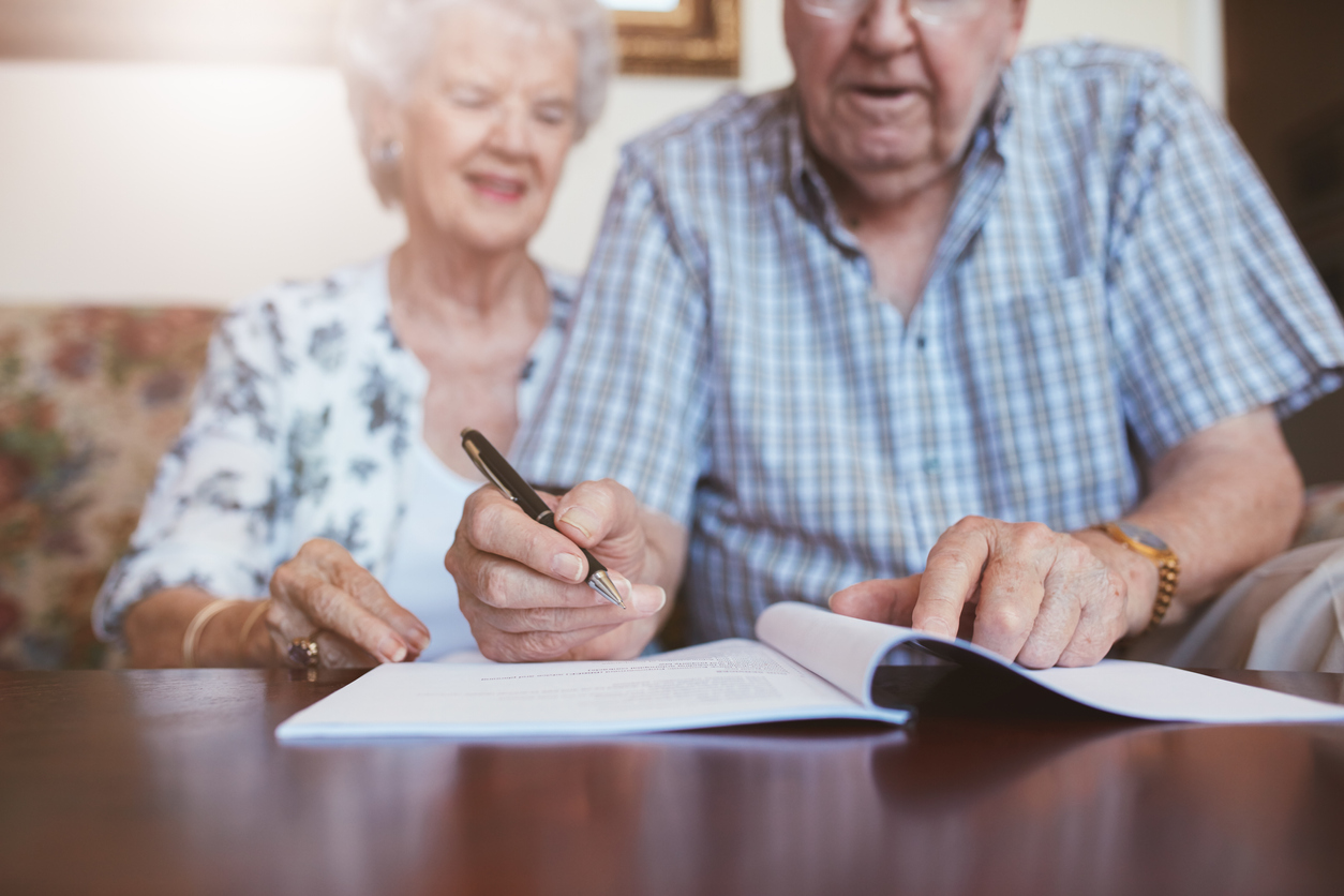 Senior couple signing retirement documents