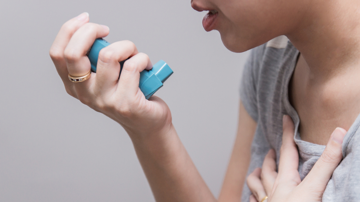 Asian woman using a pressurized cartridge inhaler extended pharynx, Bronchodilator