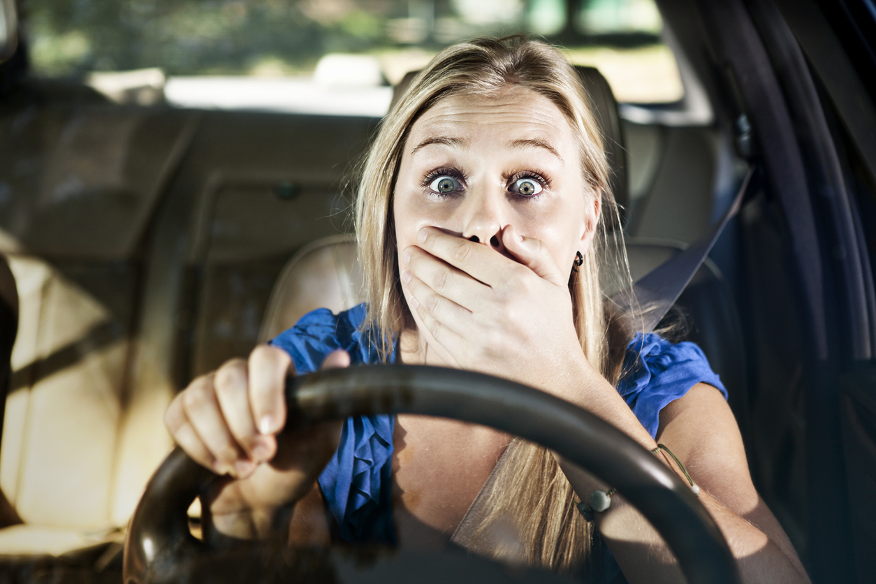 Ooops! Beautiful blonde driver, hand to mouth, looks shocked