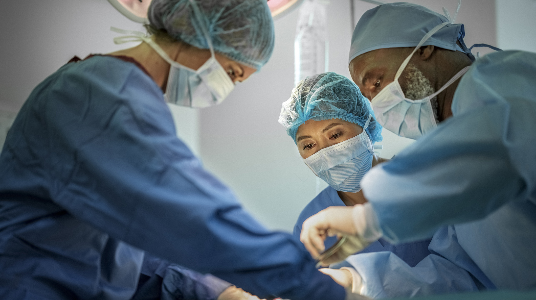 Multi-ethnic doctors operating girl at hospital