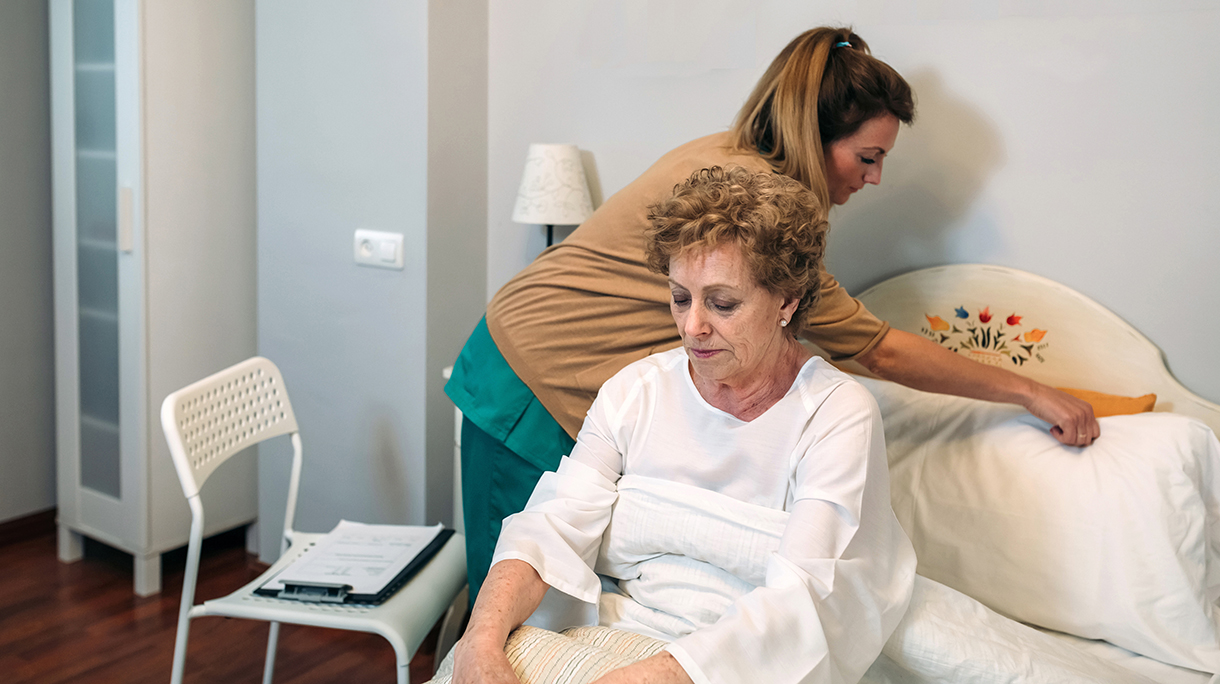 Caregiver accommodating pillow to elderly patient