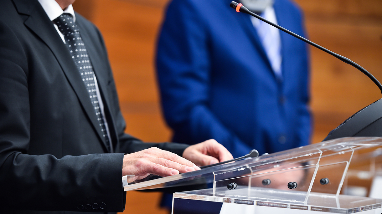 Detail shot with man in suits during a press conference