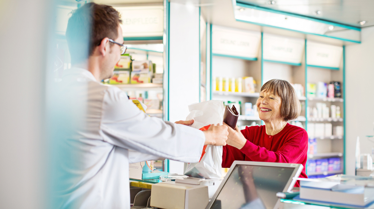 Pharmacist’s giving prescription medication to customer