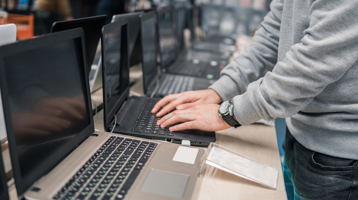 modern male customer choosing laptop in the computer store