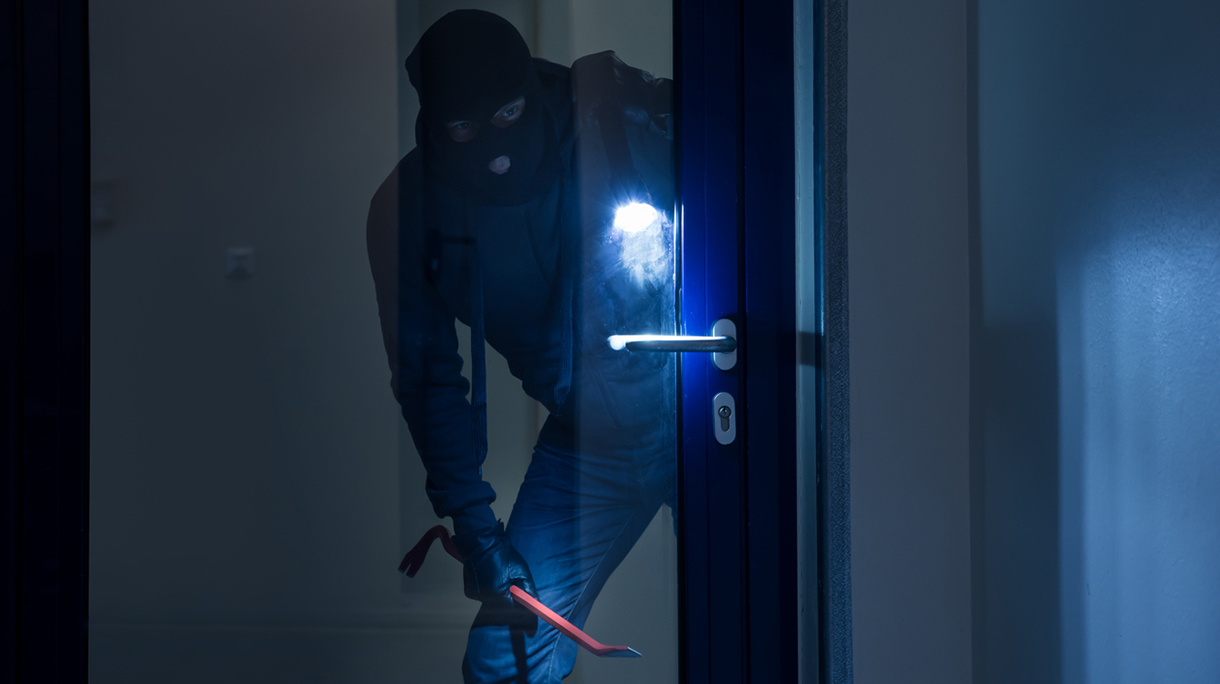 Thief With Flashlight Trying To Break Door