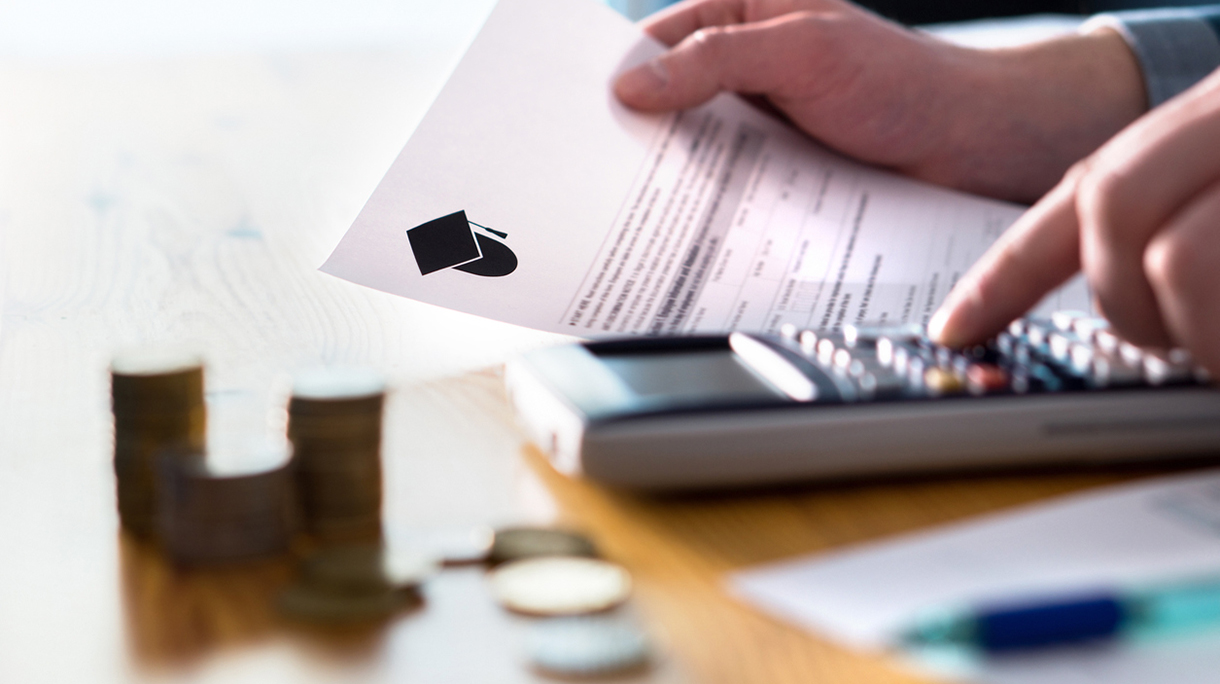 Man counting college savings fund, tuition fee or student loan with calculator. Education price and expenses concept. Money and papers on table.